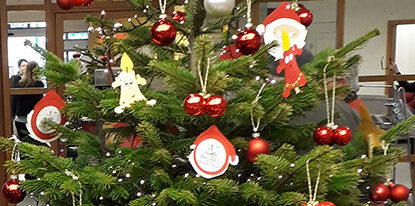 Strahlende Kinderaugen beim Schmücken des Weihnachtsbaums