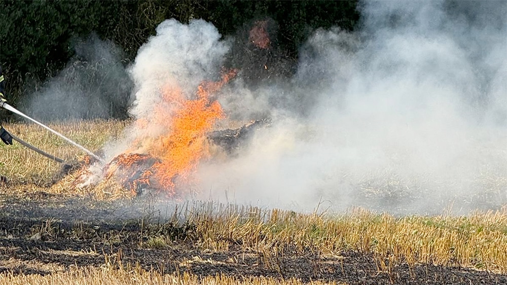 Erntemaschine fängt auf dem Feld Feuer